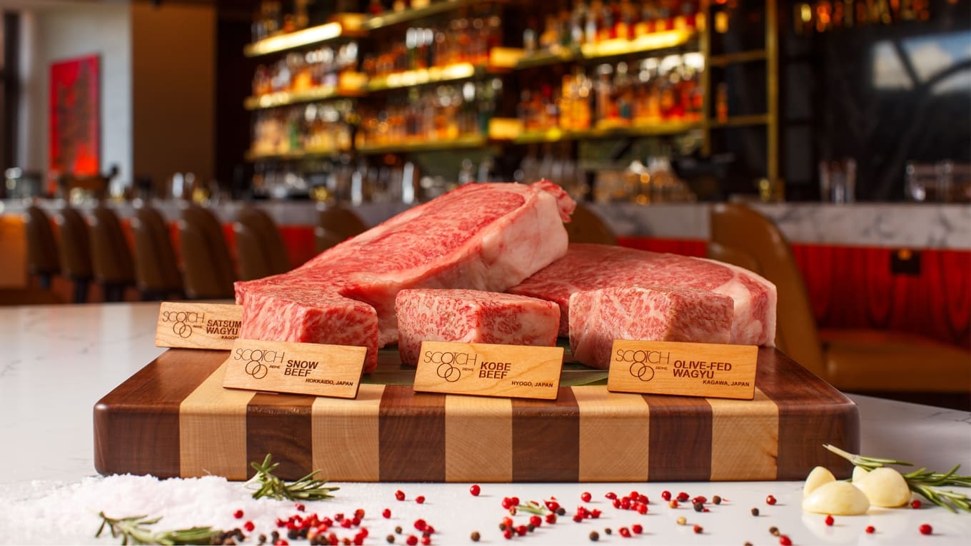 Board of Japanese wagyu and Kobe beef cuts labeled Satsuma Wagyu, Snow Beef, Kobe Beef and Olive-Fed Wagyu