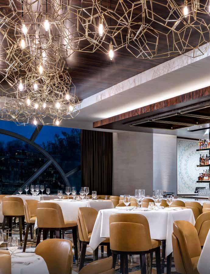 Dining room under the gold geometric chandelier beside the arched window