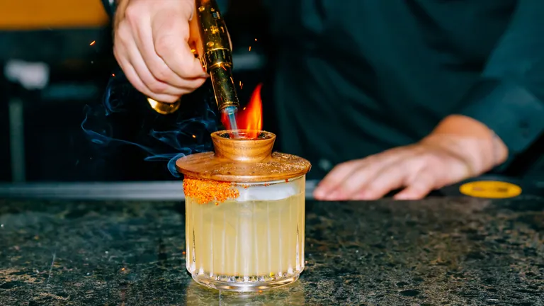 Smoked cocktail being finished with a torch behind the bar at Vinyl Room Las Vegas