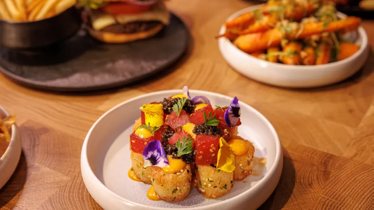 Crispy sticky rice bites topped with cubed tuna, caviar and edible flowers at Vinyl Room Las Vegas